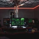Team of hackers with Guy Fawkes masks coding in a dark room with computers.