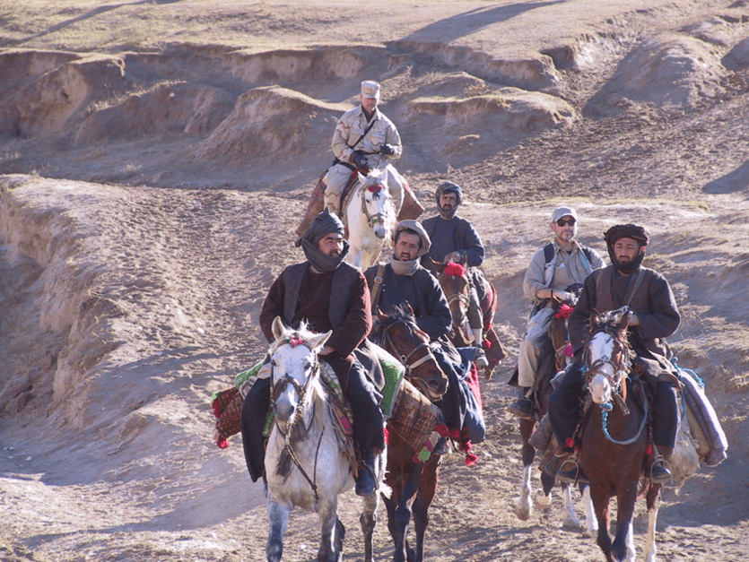 Dostum in turban on left leading U.S. Special Forces in tan fatigues (photo given by Dostum to Williams).