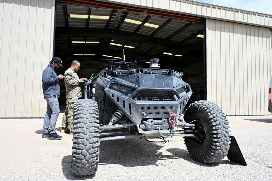 Chief Warrant Officer 2 Zackary Cowher, Cyber Capabilities Developer Technician for Multi-Domain Command - Europe, uploads configuration files to an autonomous land-based vehicle equipped with a tethered UAS quadcopter during Arcane Thunder 26 at Fort Irwin, California, April 18, 2026. Arcane Thunder 26 is a U.S. Army Europe and Africa-directed, Multi-Domain Command – Europe led exercise conducted with NATO Allies and partners across the United States and Europe. The exercise trains multi-domain capabilities by integrating cyber, space, electronic warfare, and conventional forces to strengthen interoperability and enhance NATO’s ability to deter aggression and defend the Euro-Atlantic region. (U.S. Army)